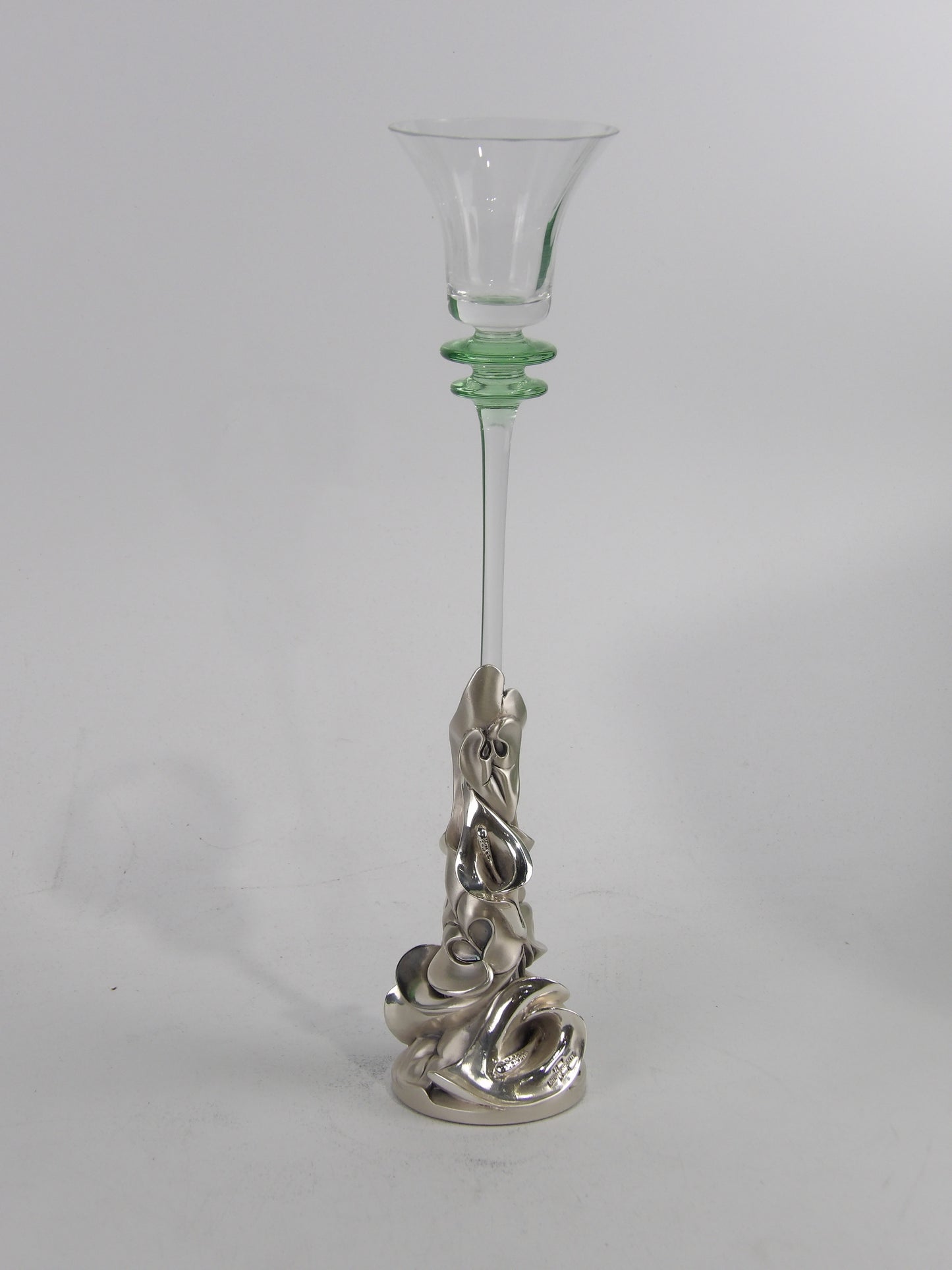 Candelabro de vidrio transparente con detalles verdes y base de resina plateada