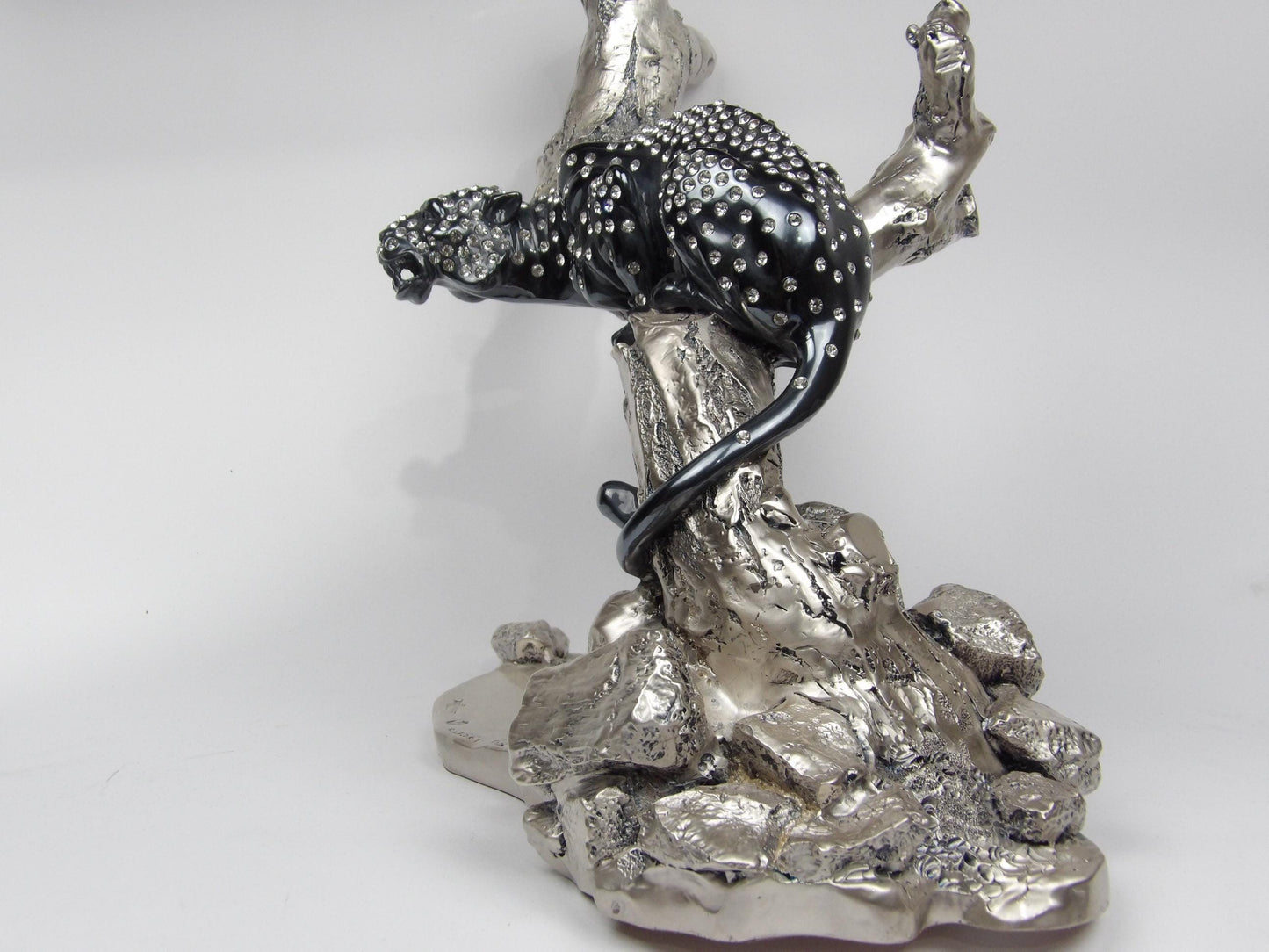 silver-coated resin sculpture with rhinestones and black parts, subject