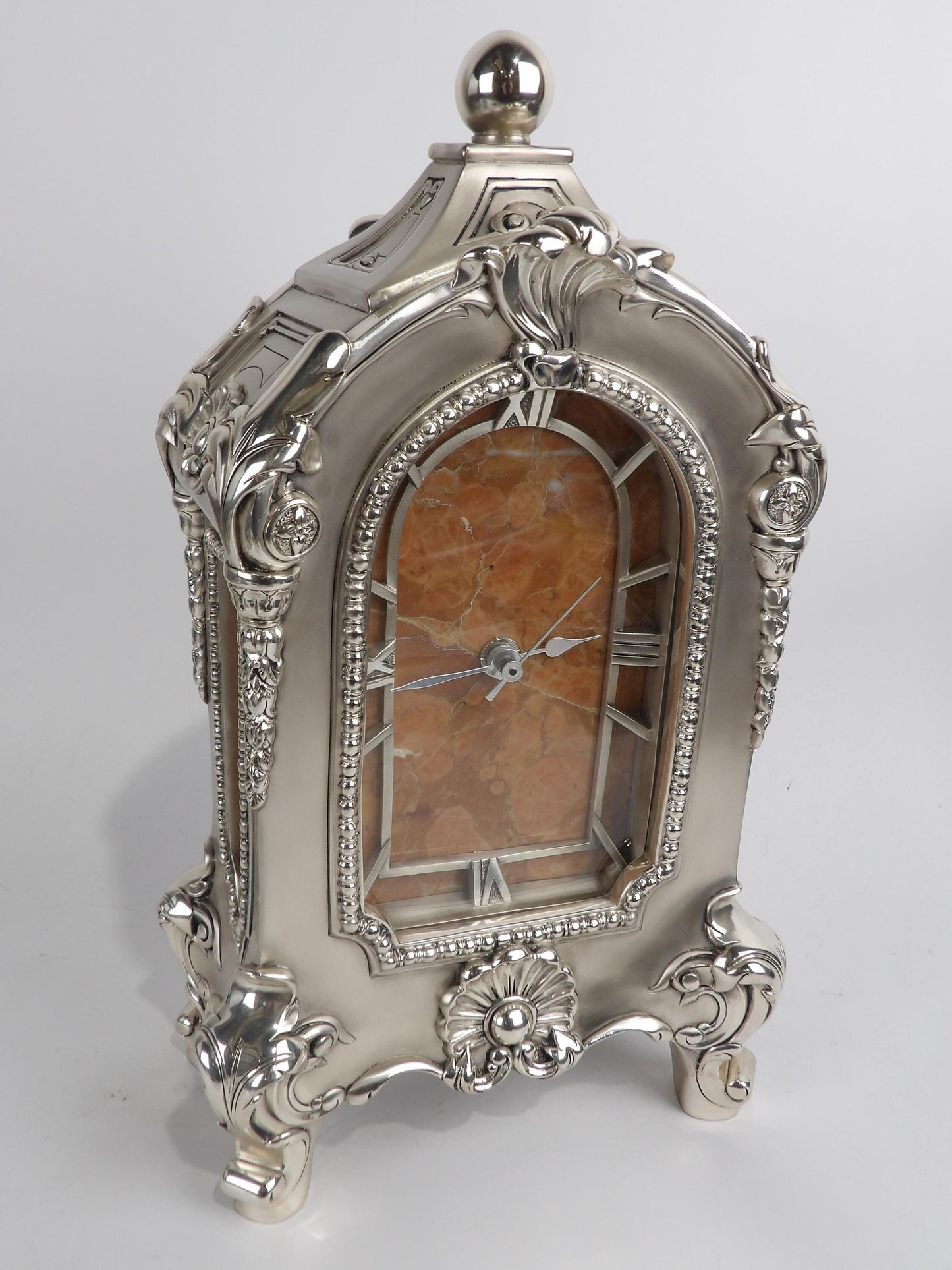 Reloj de mesa estilo imperio de resina plateada con incrustaciones de mármol rojo, elegante pieza decorativa.