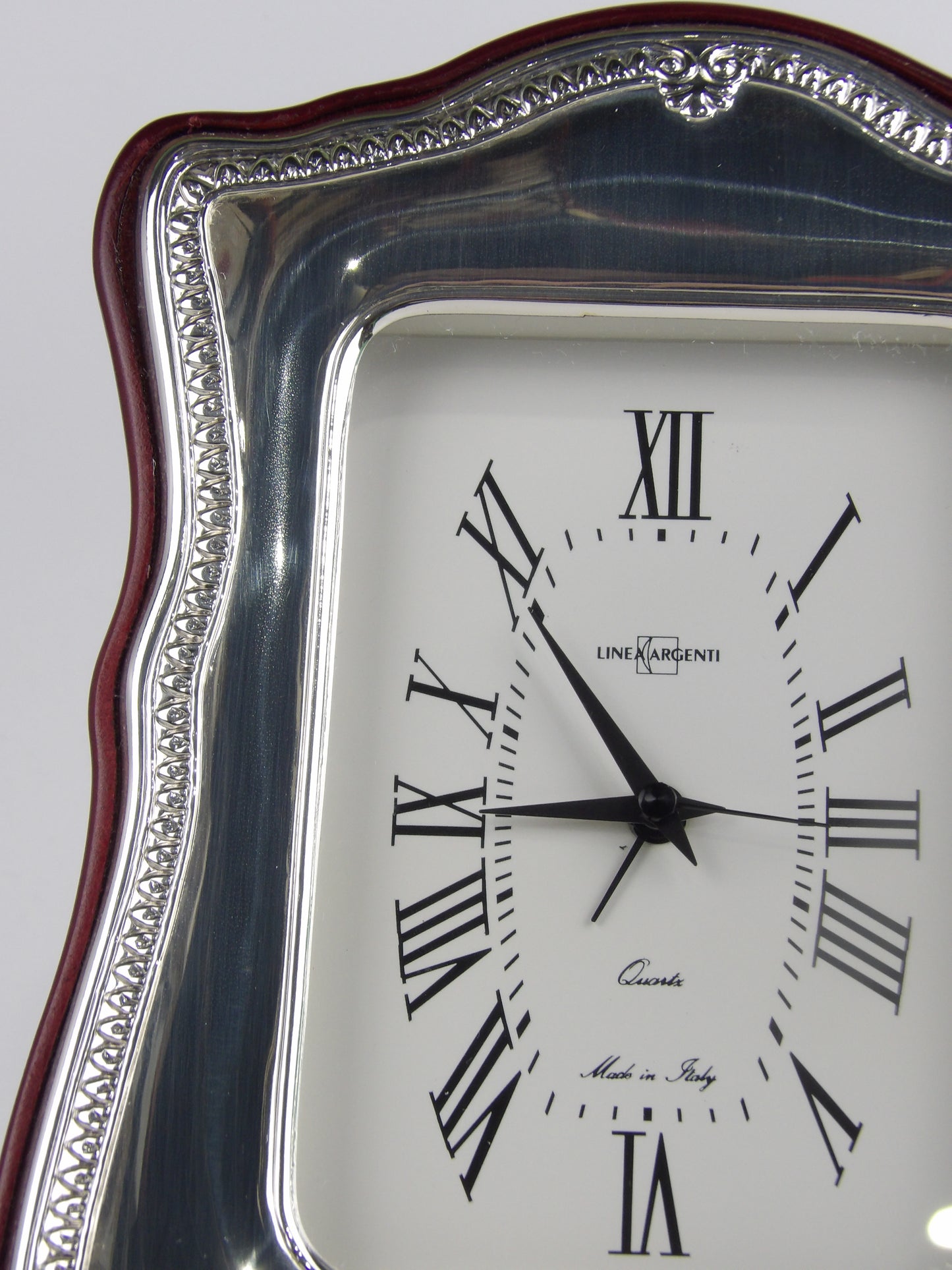 Elegante reloj de mesa con bilaminado plateado sobre marco de madera