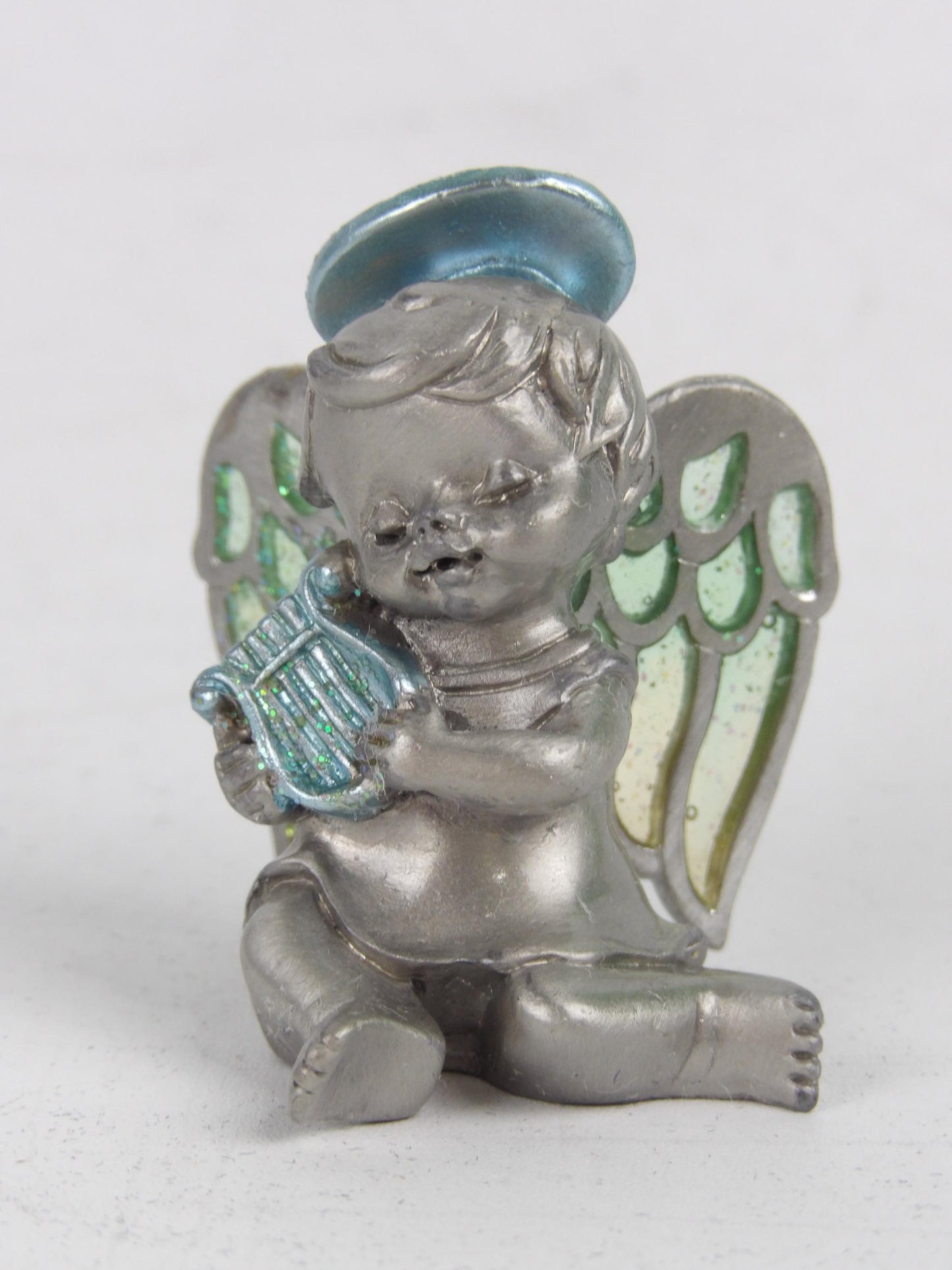Angelito de resina plateada con alas de cristal verde