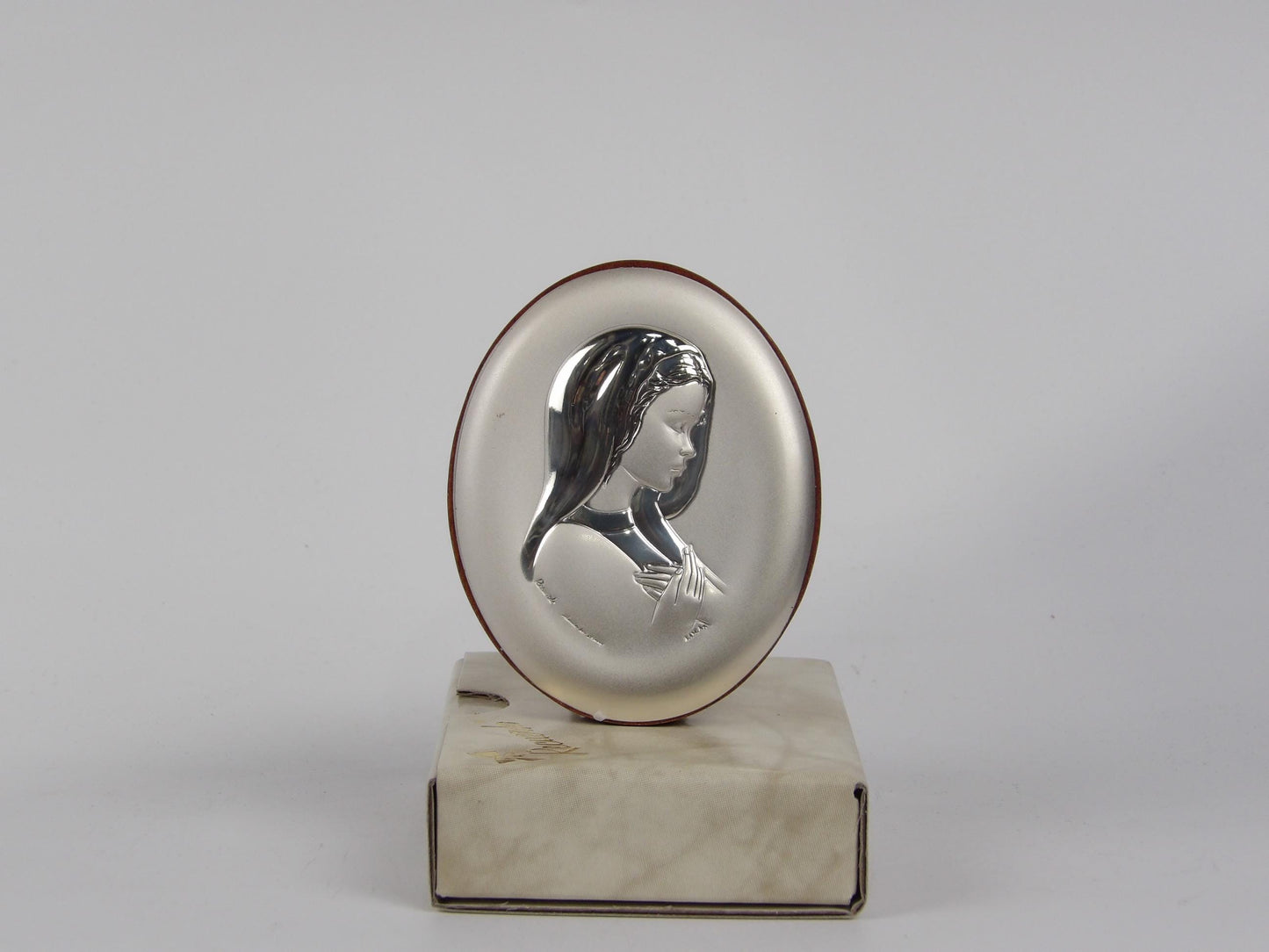 Madonna sobre base ovalada laminada en plata de caoba