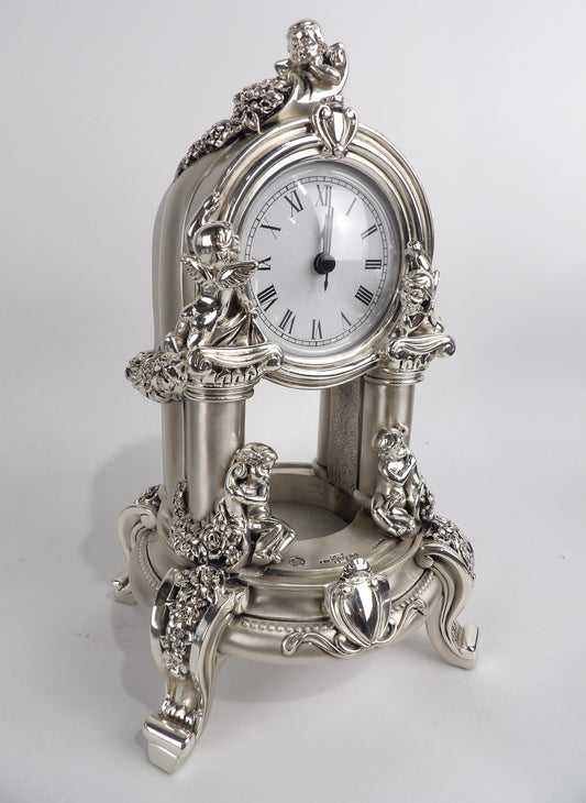 Elegante reloj de mesa plateado con motivos de querubines y volutas, decoración vintage para el hogar.